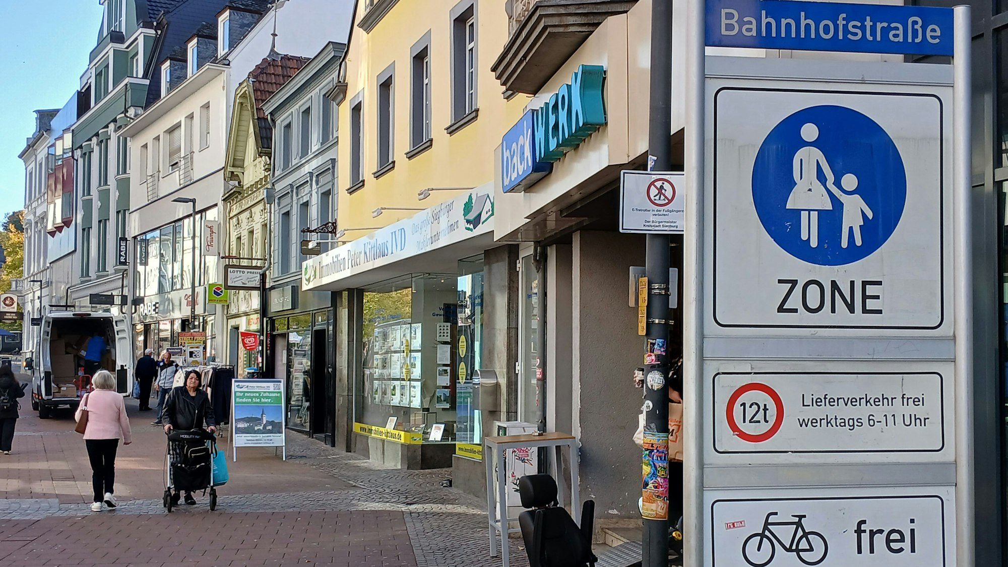 Die Siegburger Fußgängerzone ist für Radfahrer freigegeben, doch die Regelung ist umstritten. Die große Tafel rechts im Bild verdeckt das kleine Verbotsschild für E-Roller.