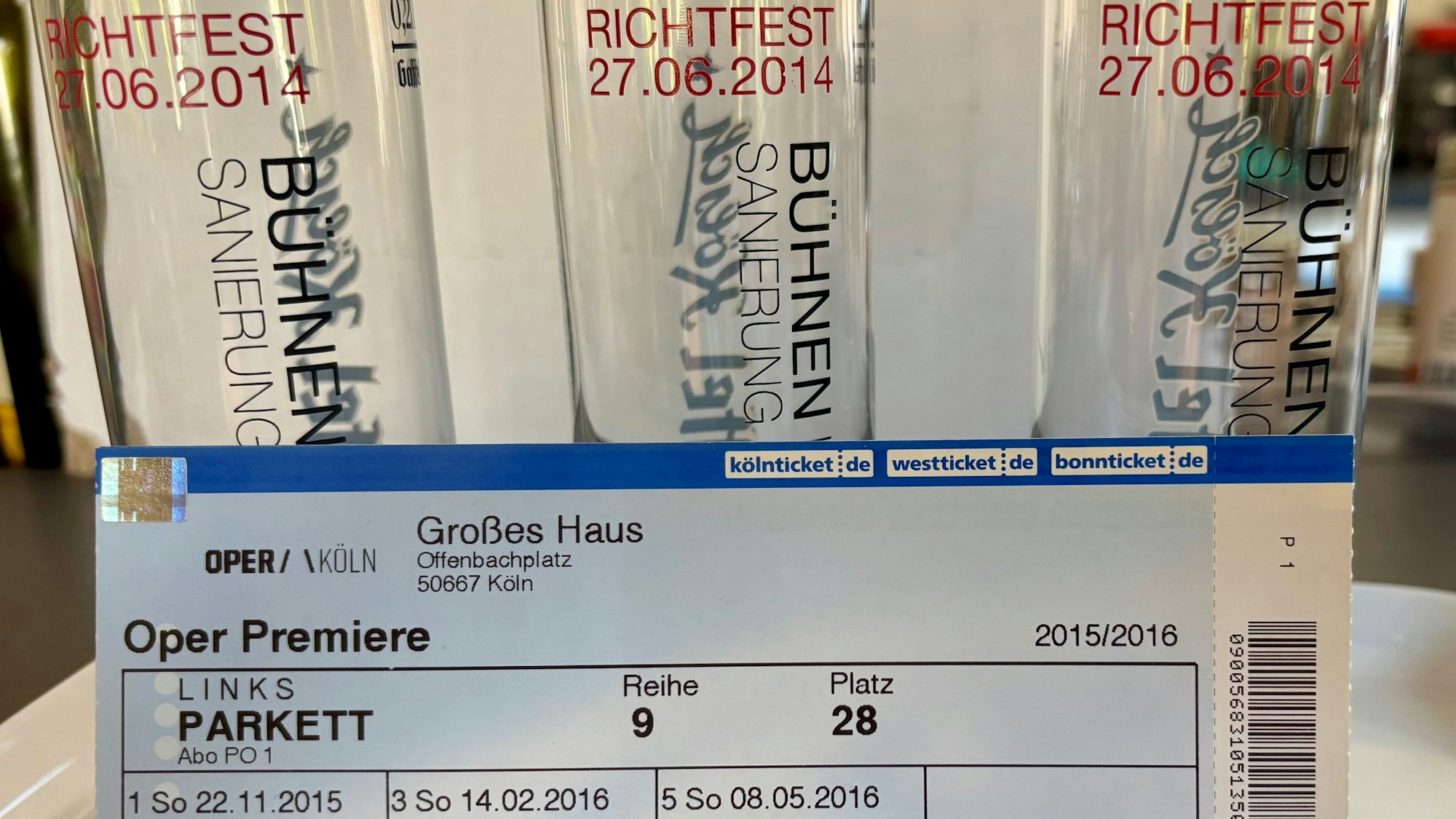 Stadtgeschichtliche Dokumente: Eintrittskarte zur geplanten Wiedereröffnung der Kölner Oper im November 2015 und Kölschgläser zum Sanierungs-Richtfest ein Jahr zuvor.