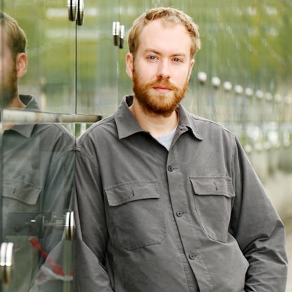 16.09.2025 Köln. Schauspiel-Dramaturg Calle Fuhr lehnt an der Glaswand des Neven-DuMont-Hauses in Köln.