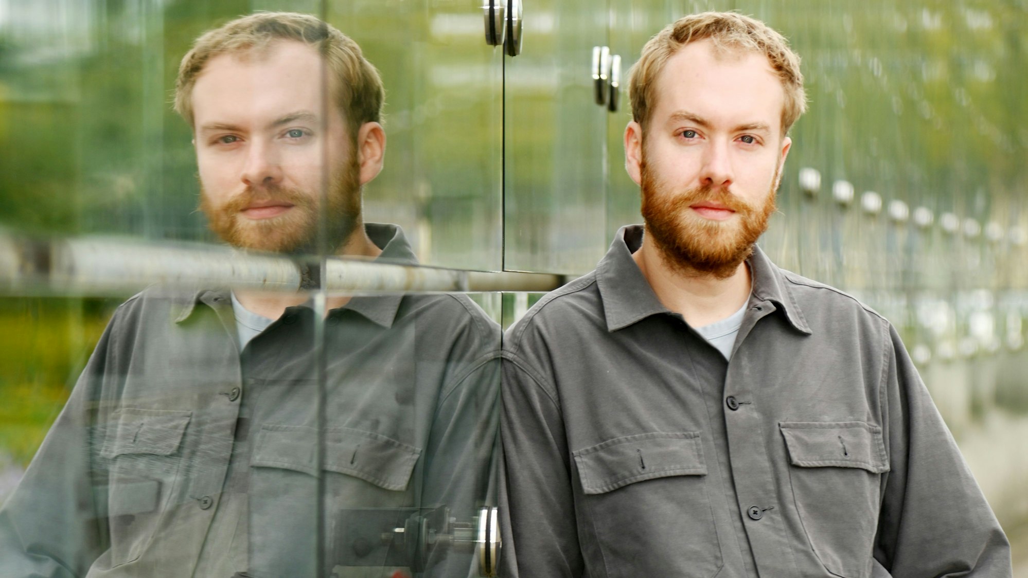 16.09.2025 Köln. Schauspiel-Dramaturg Calle Fuhr lehnt an der Glaswand des Neven-DuMont-Hauses in Köln.