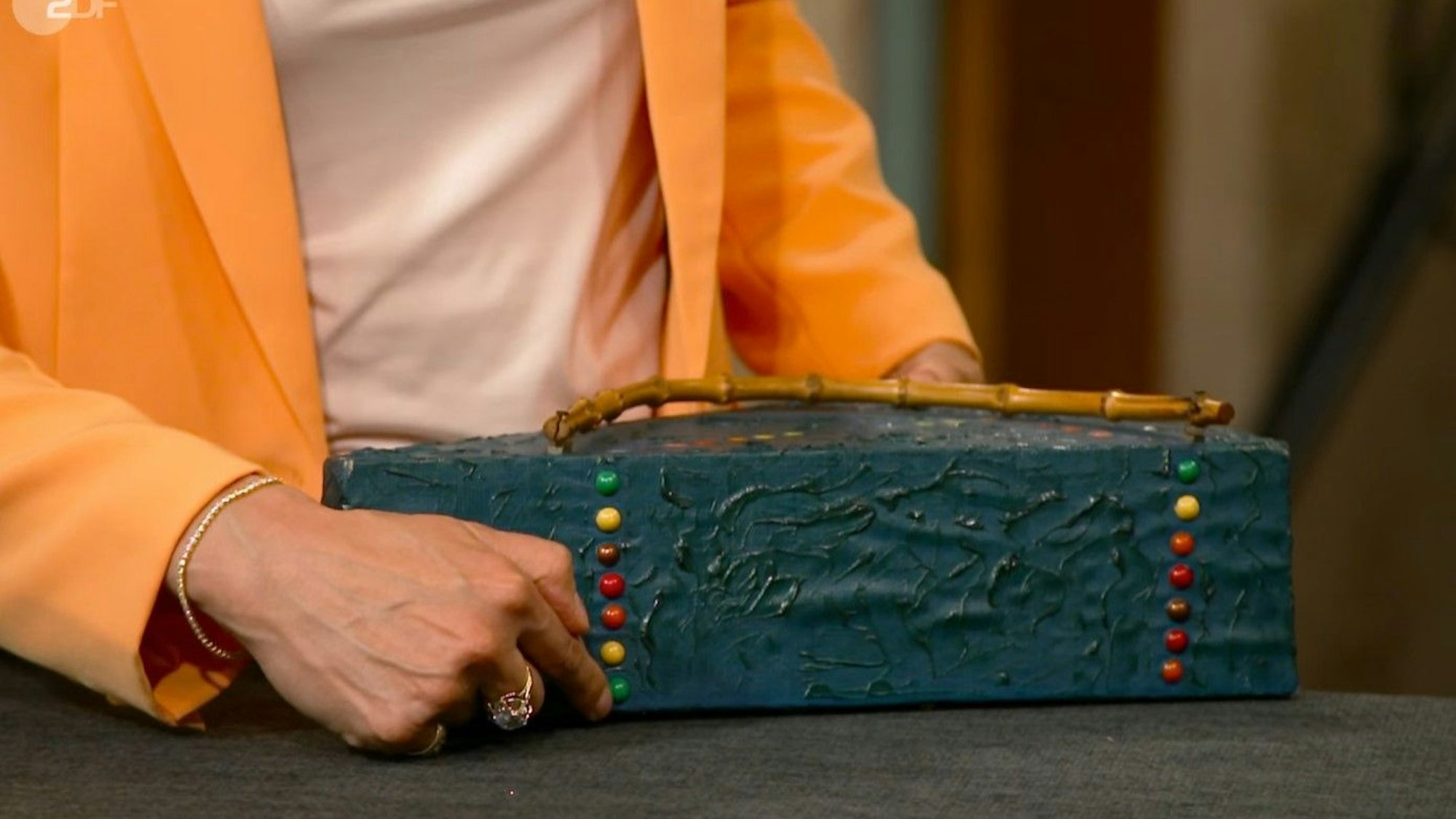 „Bares für Rares“-Expertin Bianca Berding weist auf die echten Stecknadelköpfe auf der Unterseite hin.