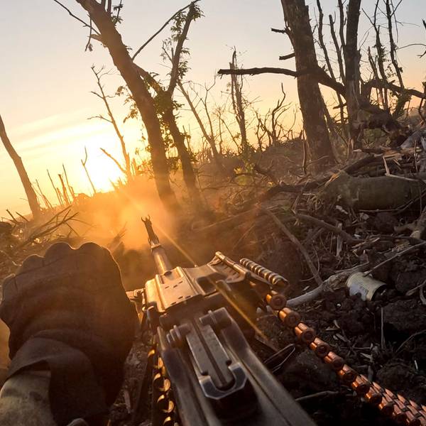 Ein Soldat schaut über sein Maschinengewehr in einen zerstörten Wald.