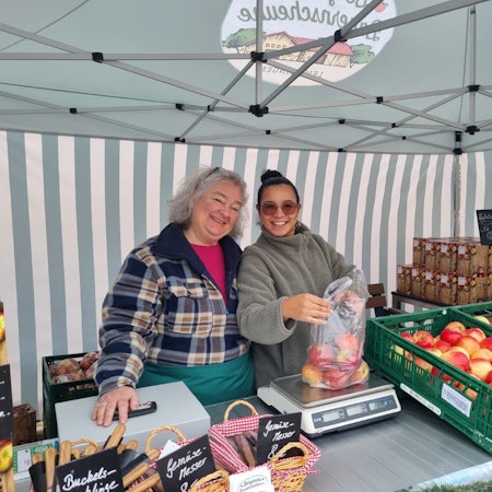 Claudia und Carla verkaufen am Stand der Bergischen Bauernscheune Äpfel aus der Region.