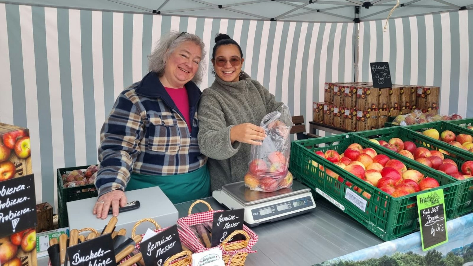 Claudia und Carla verkaufen am Stand der Bergischen Bauernscheune Äpfel aus der Region.