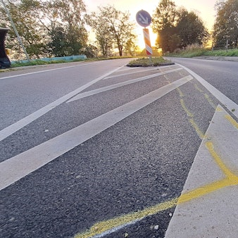 Unfallmarkierungen sind auf der Kreisstraße bei Rösrath-Stöcken vor einer Verkehrsinsel zu sehen.