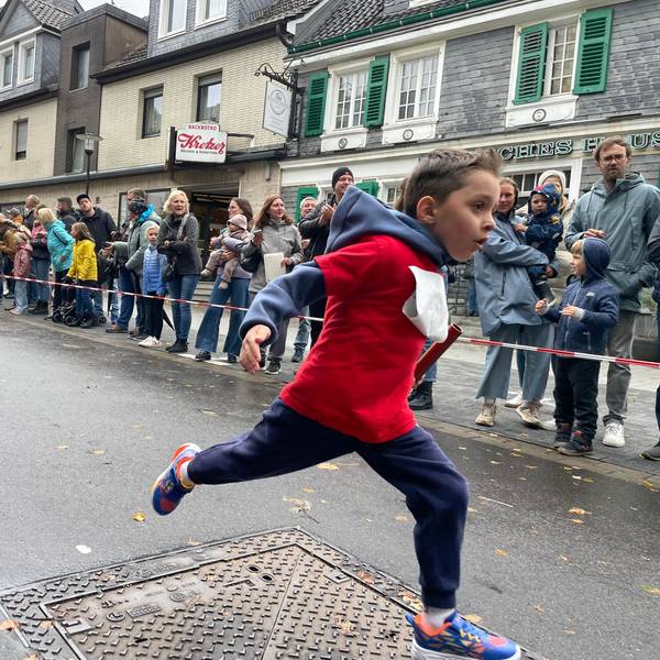 Junge läuft ins Ziel.