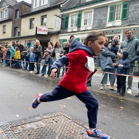 Junge läuft ins Ziel.