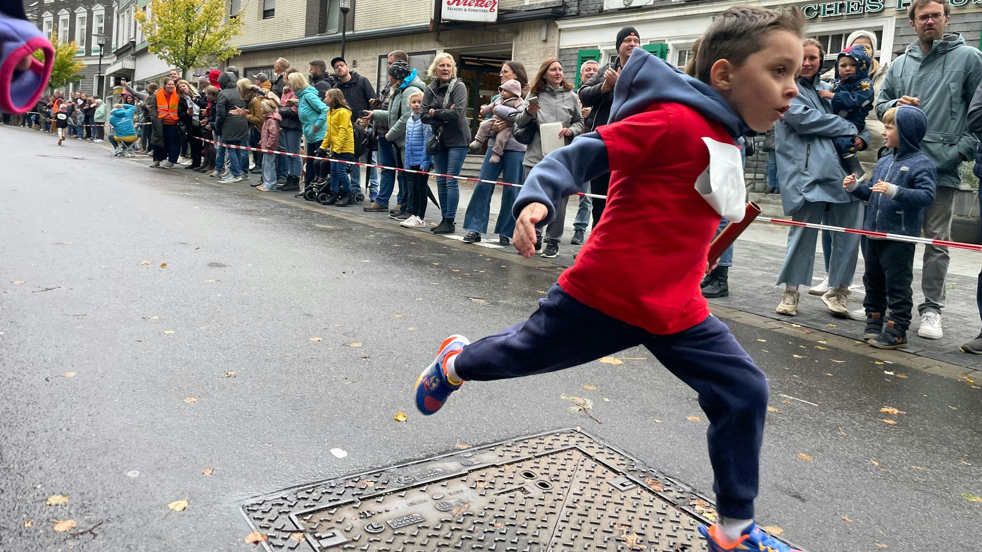 Junge läuft ins Ziel.