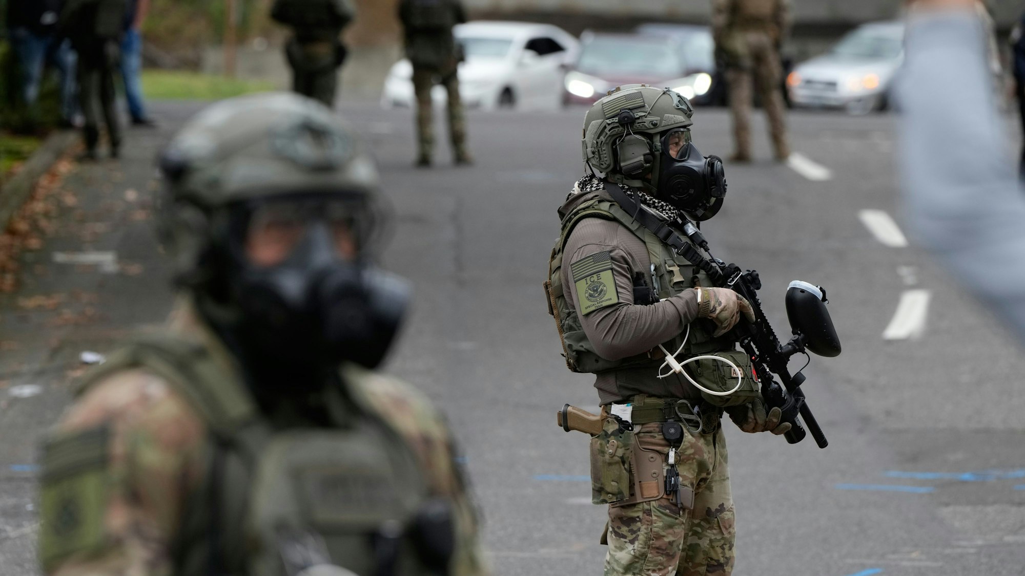 04.10.2025, USA, Portland: Beamte der Einwanderungs- und Zollbehörde stehen während einer Demonstration vor einer ICE-Einrichtung. Foto: Jenny Kane/AP/dpa +++ dpa-Bildfunk +++