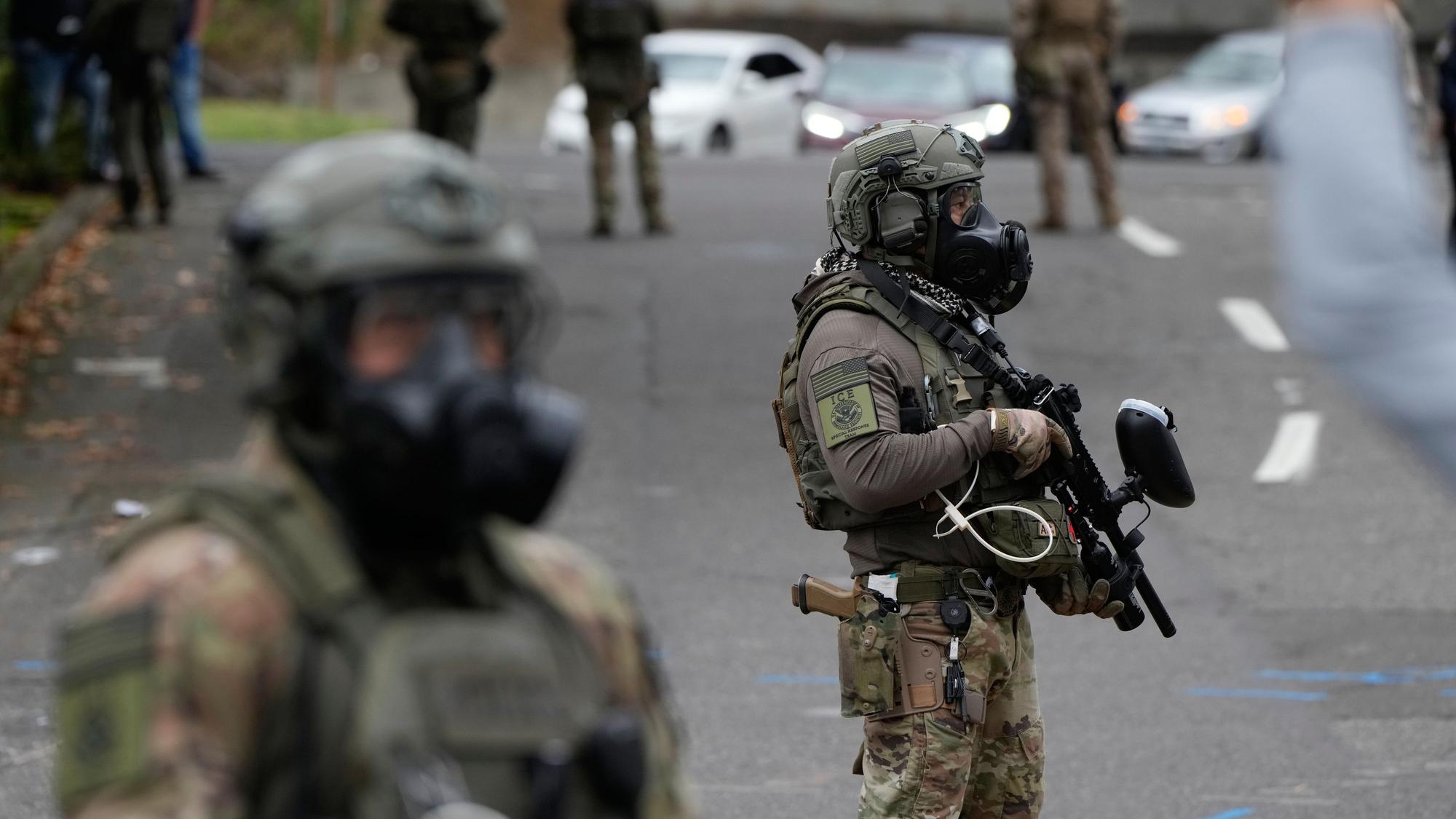 04.10.2025, USA, Portland: Beamte der Einwanderungs- und Zollbehörde stehen während einer Demonstration vor einer ICE-Einrichtung. Foto: Jenny Kane/AP/dpa +++ dpa-Bildfunk +++