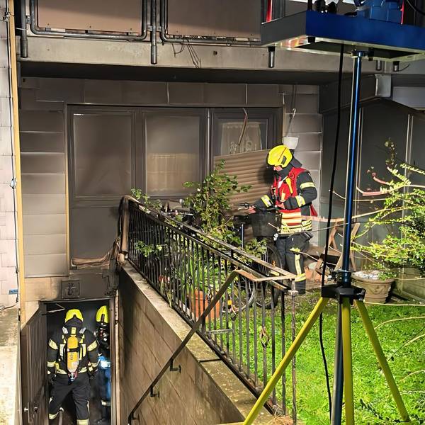 Zu sehen sind Feuerwehrleute beim Einsatz an dem Mehrfamilienhaus in Bergheim-Niederaußem.