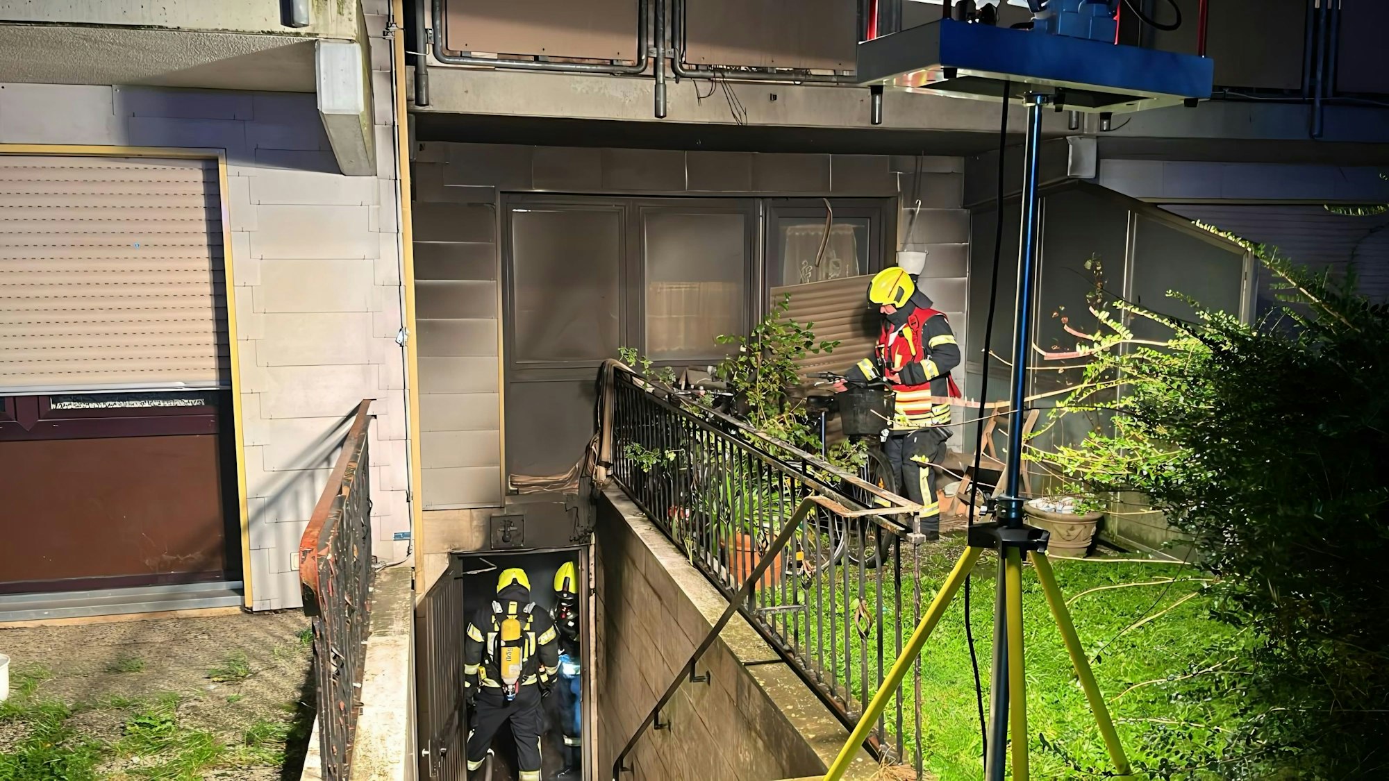 Zu sehen sind Feuerwehrleute beim Einsatz an dem Mehrfamilienhaus in Bergheim-Niederaußem.