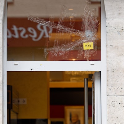 Einschusslöcher sind in einem Fenster über dem Eingang zu einer Konditorei zu sehen.
