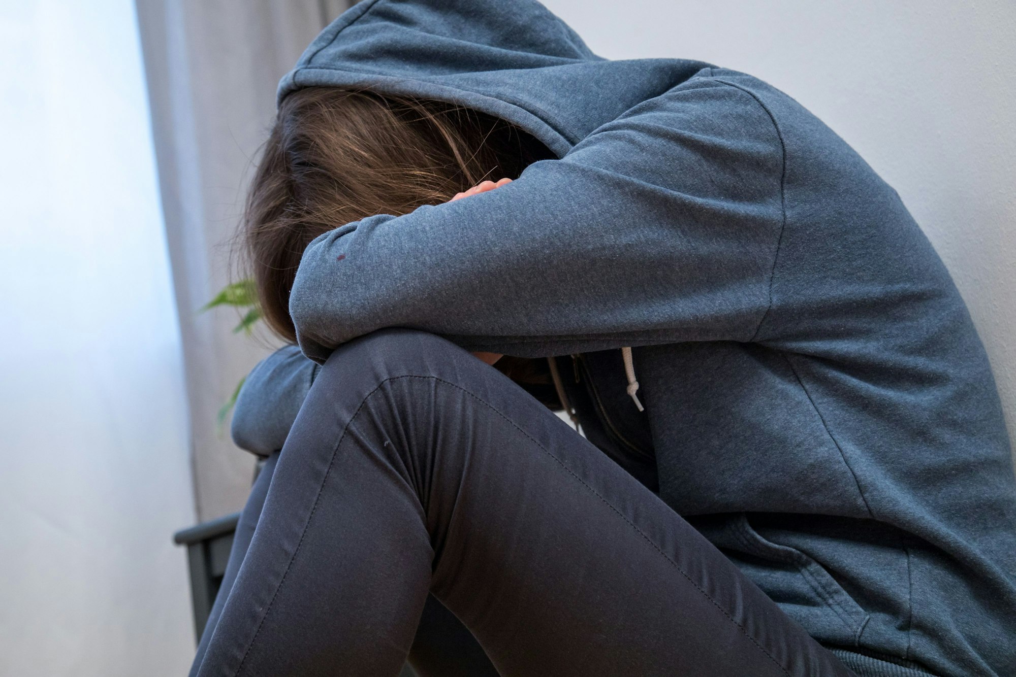 Eine junge Frau sitzt alleine auf dem Boden. Doch gerade die Vereinzelung ist nicht nur persönlich gefährlich, sondern auch gesellschaftlich.