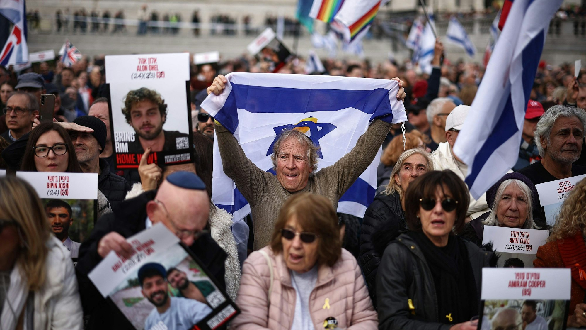 TOPSHOT - People hold photos of hostages and Israeli flags as they gather for a commemorative event organized by the Jewish community to honour the lives lost in the Hamas attack on October 7, 2023, in Trafalgar Square, London on October 5, 2025. Israeli and Hamas negotiators were converging on Cairo Sunday for talks to end nearly two years of war in Gaza, with Israel's leader expressing hope that hostages held in the devastated territory could be released within days. (Photo by HENRY NICHOLLS / AFP)