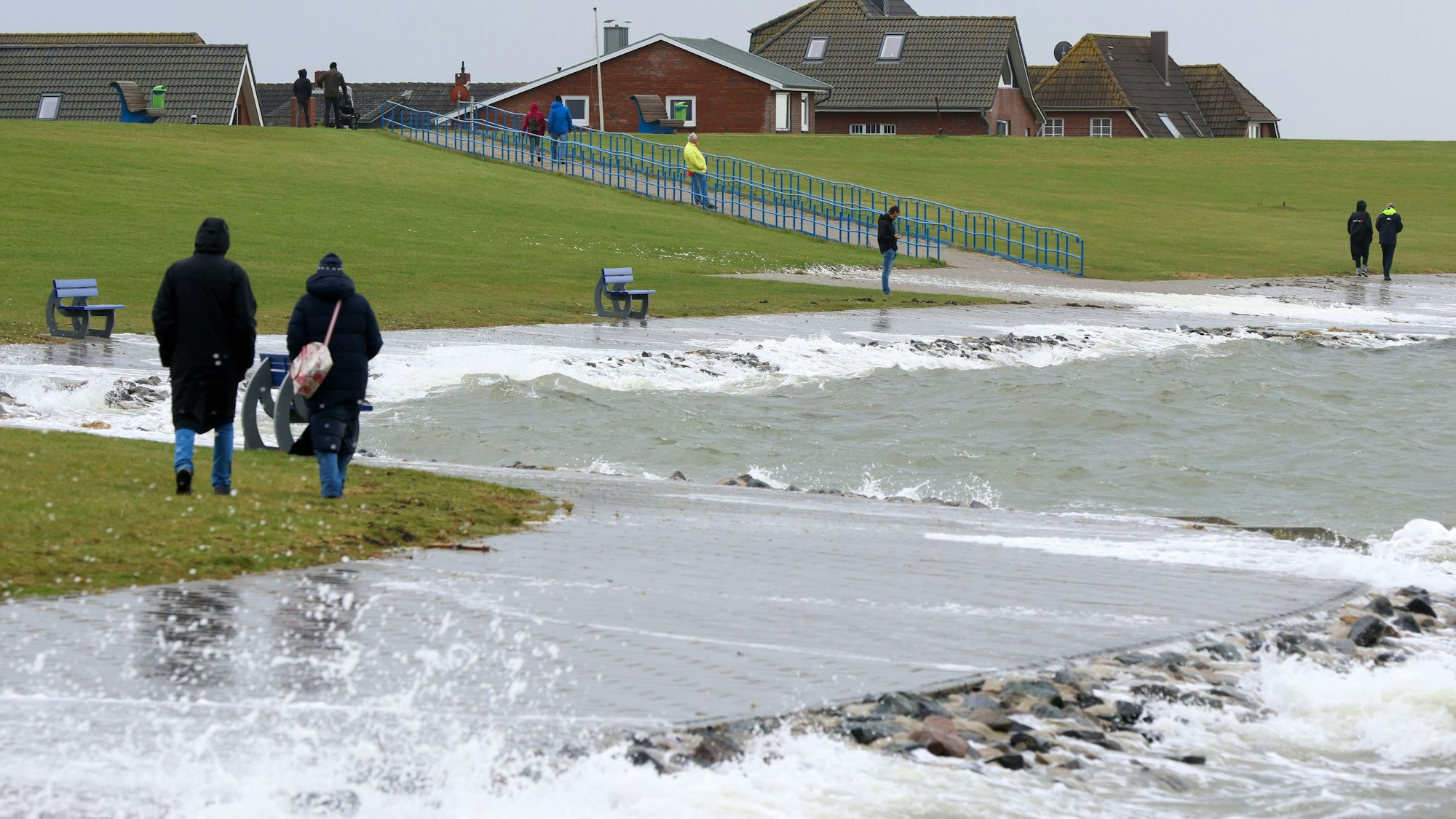 05.10.2025, Schleswig-Holstein, Dagebüll: Spaziergänger sind bei einer Sturmflut an der Nordsee in Dagebüll unterwegs. Die angekündigte Sturmflut hat die schleswig-holsteinische Nordseeküste erreicht. Foto: Bodo Marks/dpa +++ dpa-Bildfunk +++