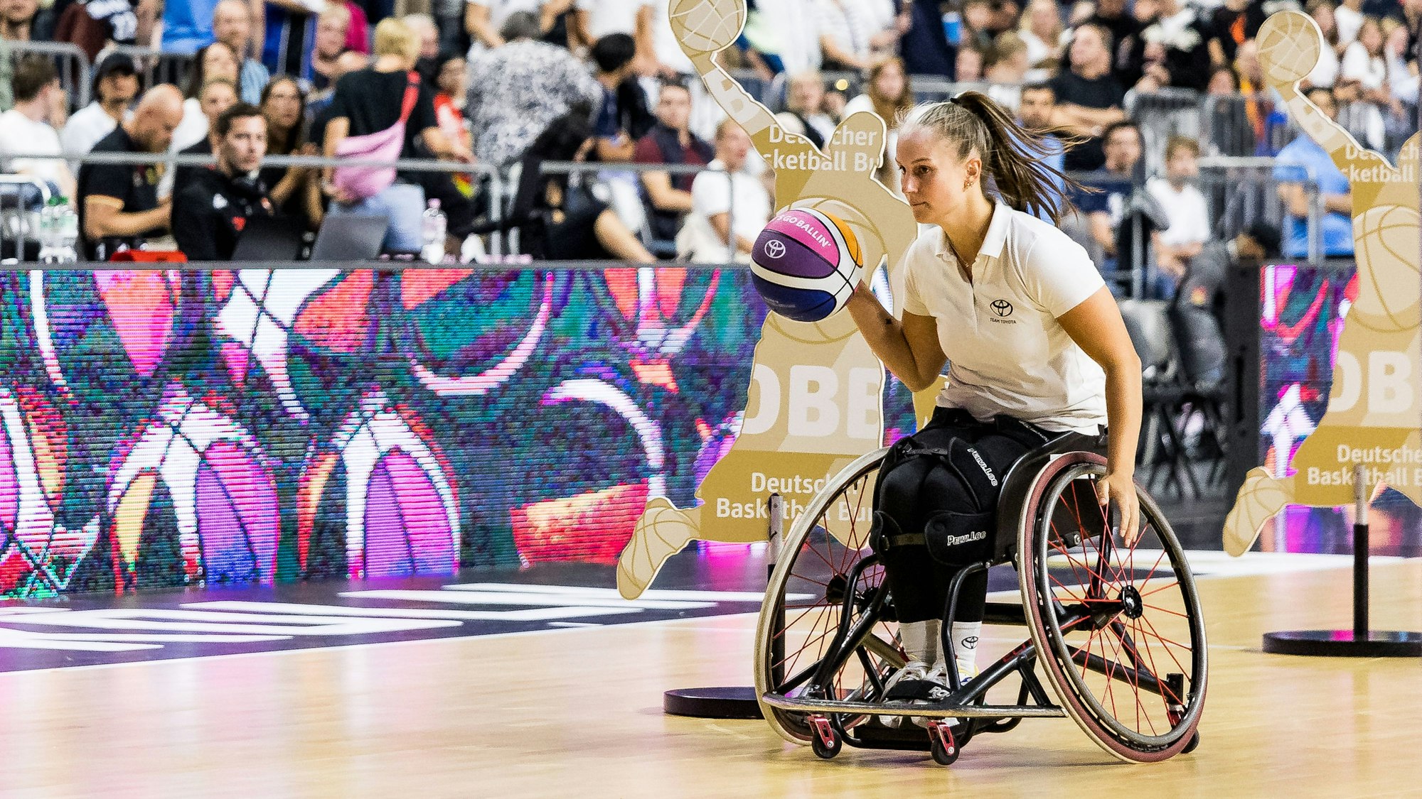 Rollstuhlbasketballerin Lisa Bergenthal während einer Halbzeit-Challenge in der Lanxessarena im August 2025: Jetzt ist sie Sportvorbild für Kölner Schüler.