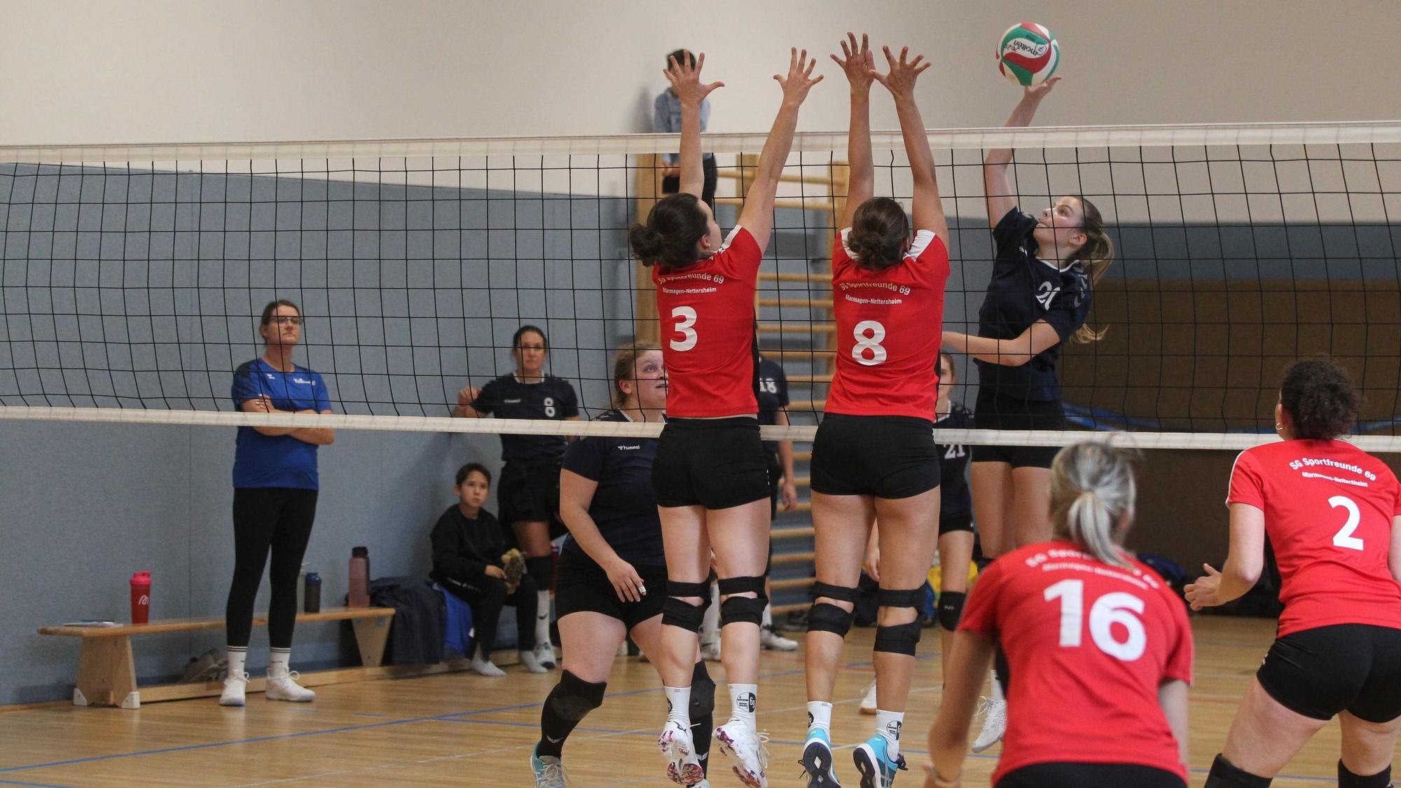 Volleyballer der Sportfreunde 69 und von Stotzheim in roten und schwarzen Trikots spiel gegeneinander.
