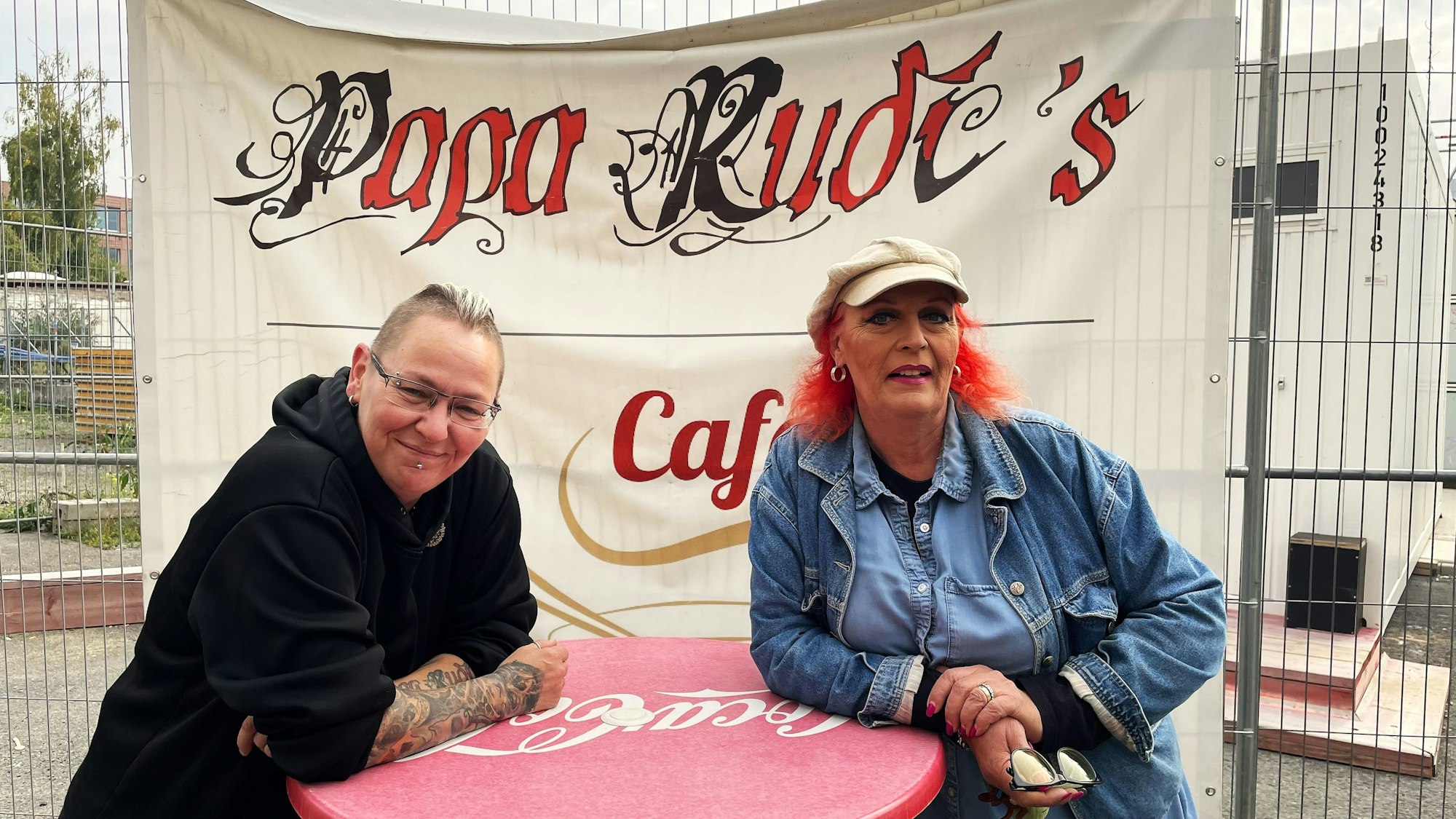 Zwei Frauen stehen an einem Stehtisch am Einsturzloch des Kölner Stadtarchivs.