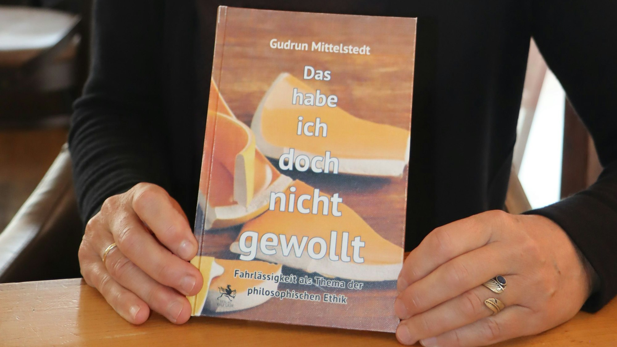 Eine Person hält ein Buch in ihren Händen.