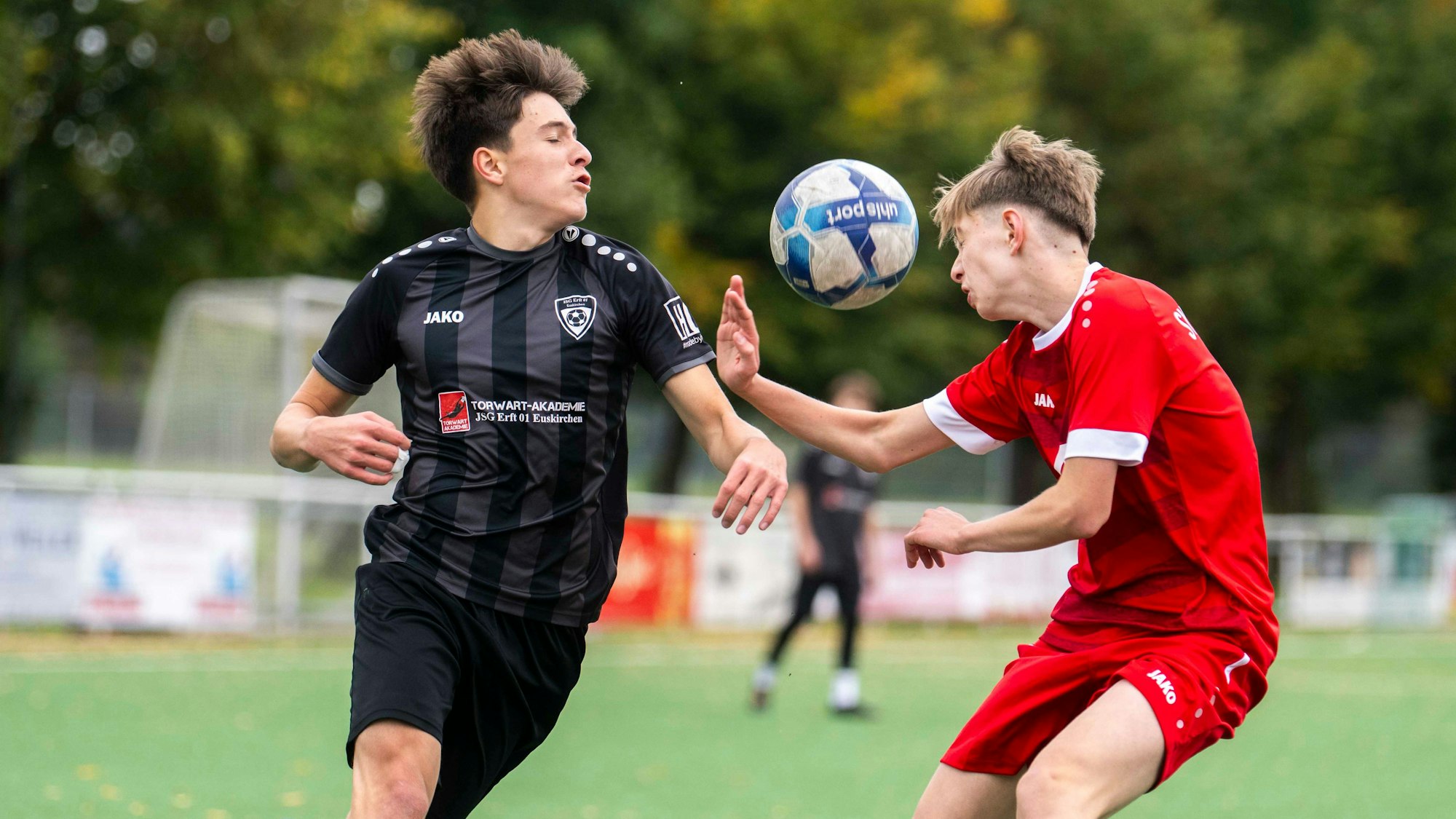 Der Ball in der Luft steht zwischen einem Spieler der JSG Erft und von Rot-Weiß Billig.