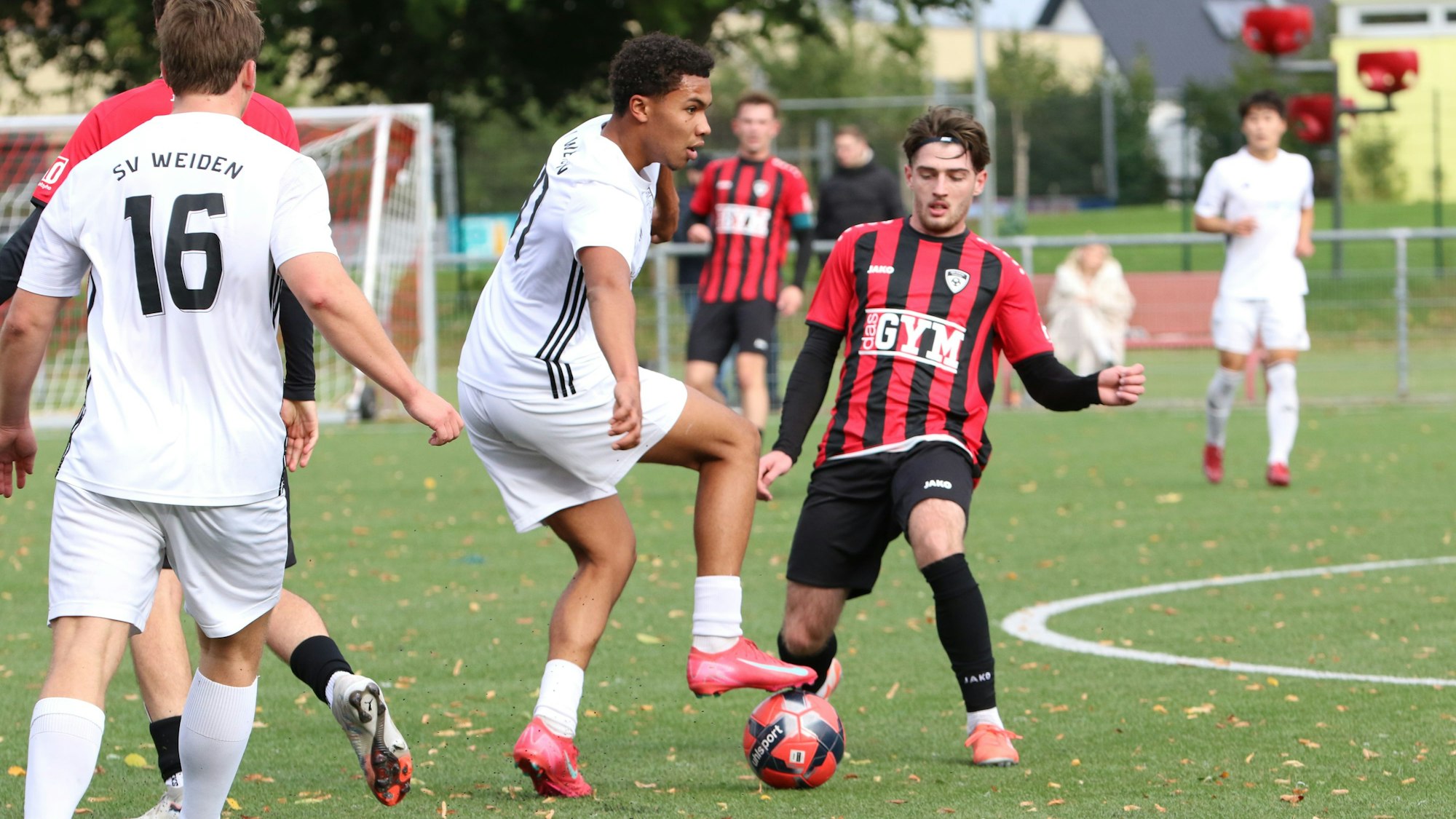 Ein Fußballer des SV Weiden tritt auf den Ball, der Gegenspieler der JSG Erft schaut auf den Ball.