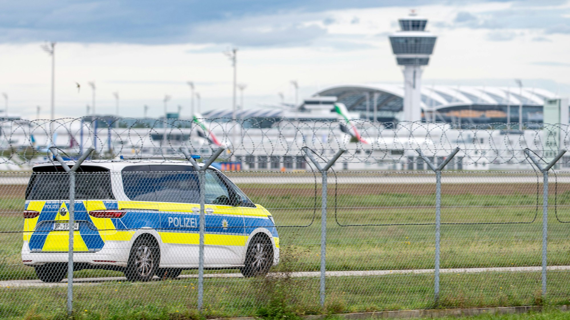 Ein Polizeifahrzeug auf dem Gelände des Münchner Flughafens, über dem Drohnen gesichtet wurden