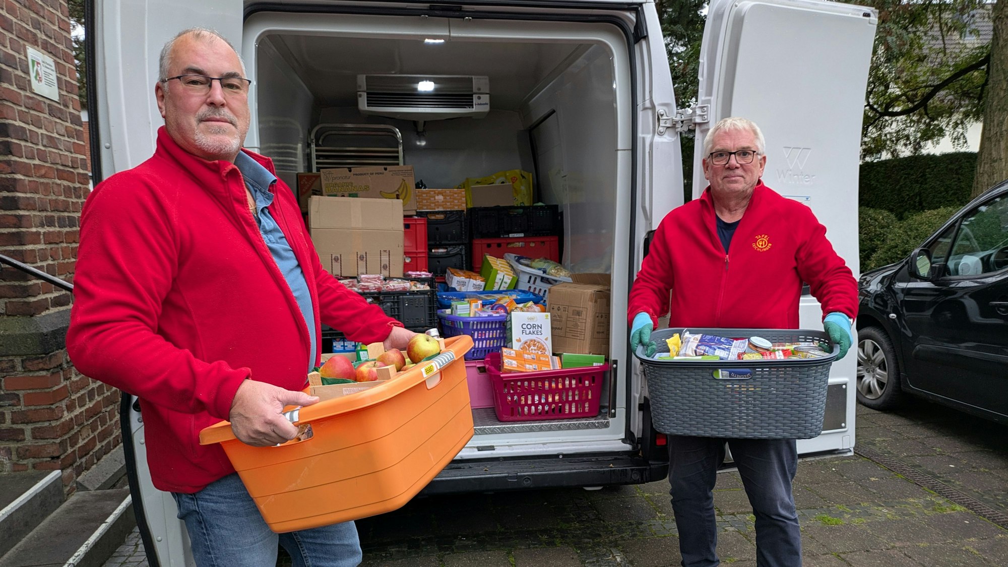 Helfer der Leichlinger Tafel laden die gespendeten Lebensmittel vor St. Johannes Baptist in den Kleintransporter des Vereins.