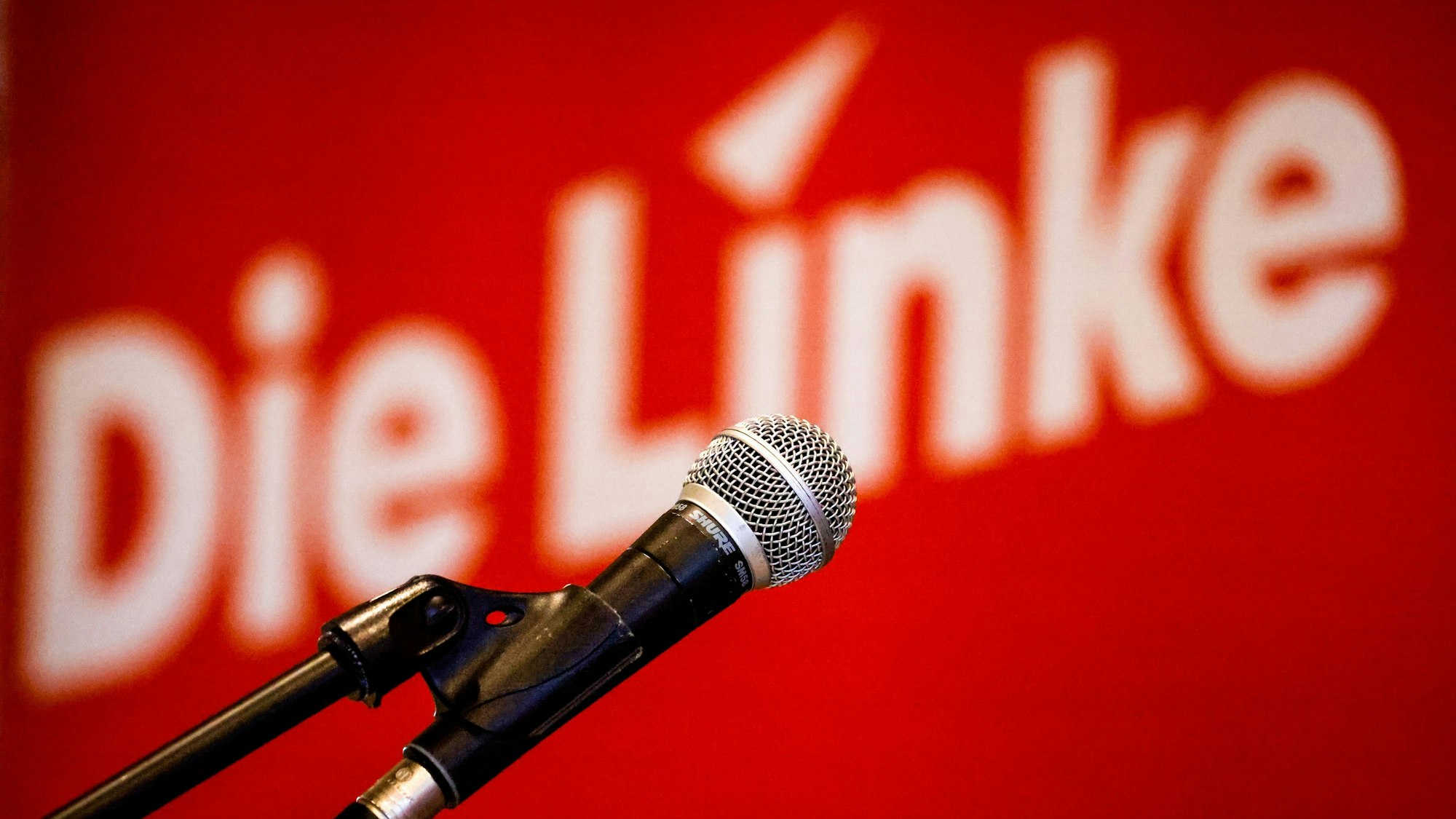 Ein Mikrofon hängt vor dem Landesparteitag der Partei Die Linke Bremen im Bürgerhaus Mahndorf vor einem Parteilogo. In einem Leitantrag zieht die Partei eine Bilanz der aktuellen Legislaturperiode. +++ dpa-Bildfunk +++