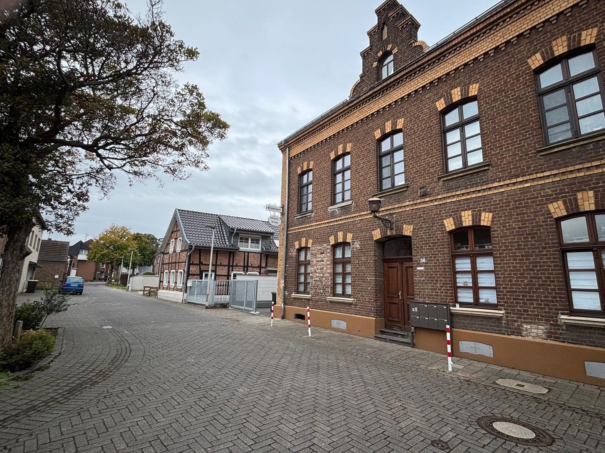 Auf dem Bild ist eine Straße und ein altes Backsteingebäude zu sehen.