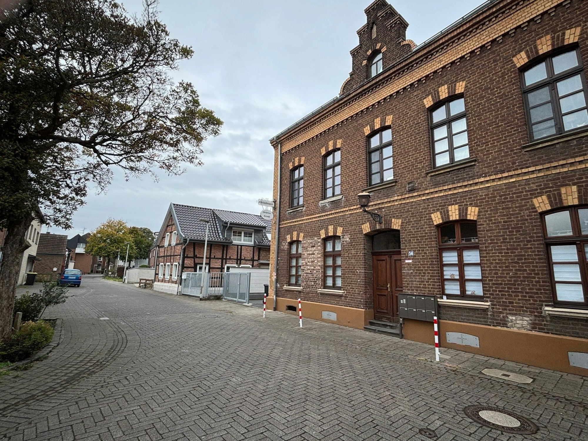 Auf dem Bild ist eine Straße und ein altes Backsteingebäude zu sehen.