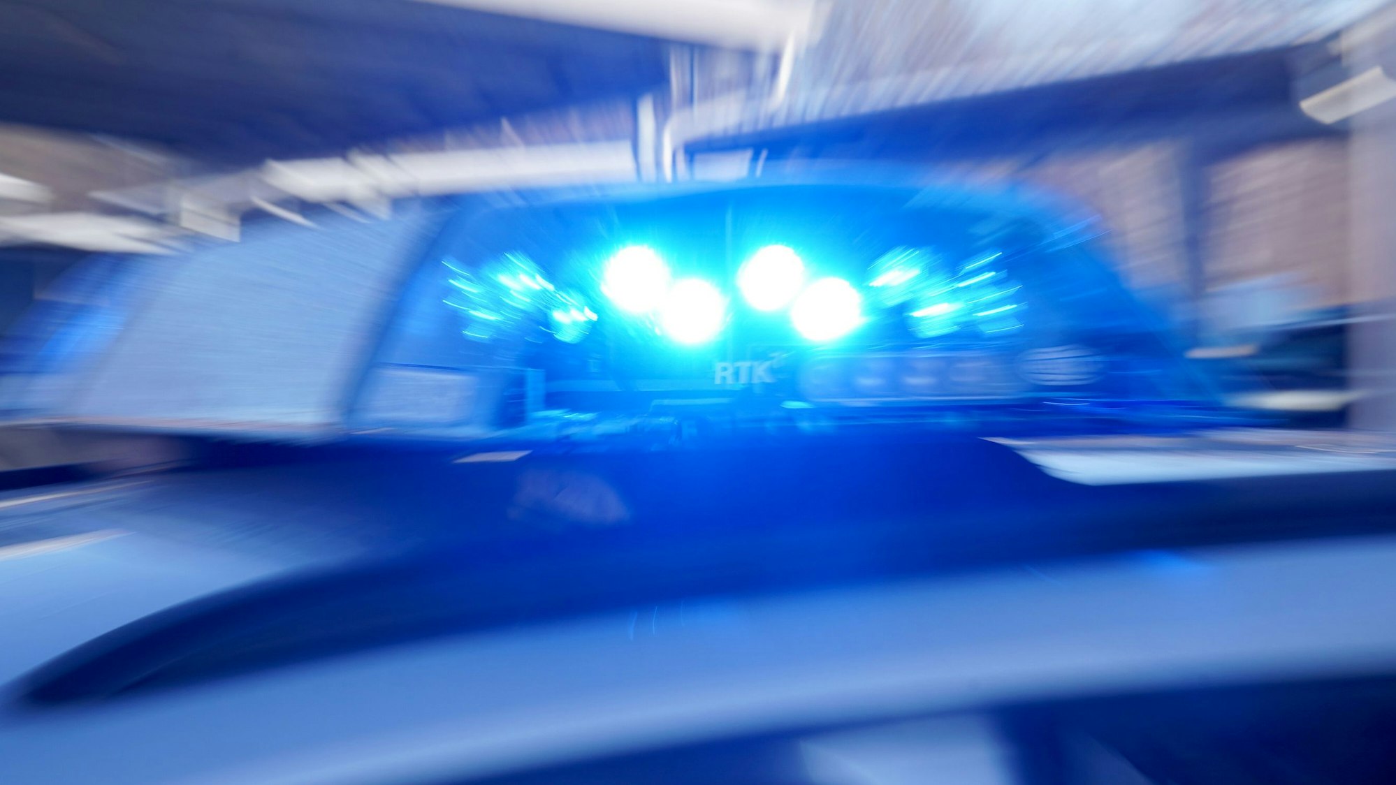 Ein Polizeiauto ist mit Blaulicht unterwegs.