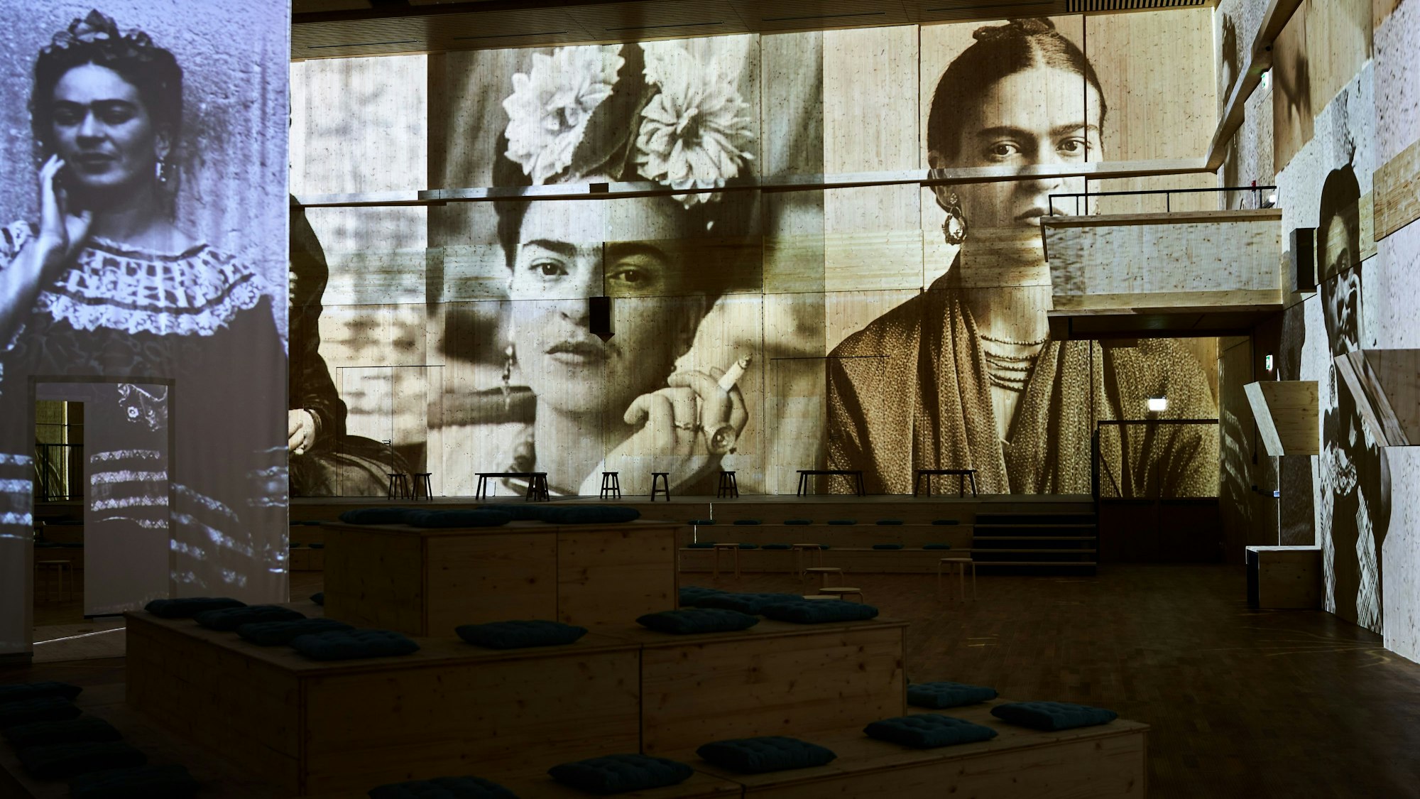 Bilder von Frida Kahlo, davor Sitzplätze bei der Ausstellung Viva Frida Kahlo – Immersive Experience.