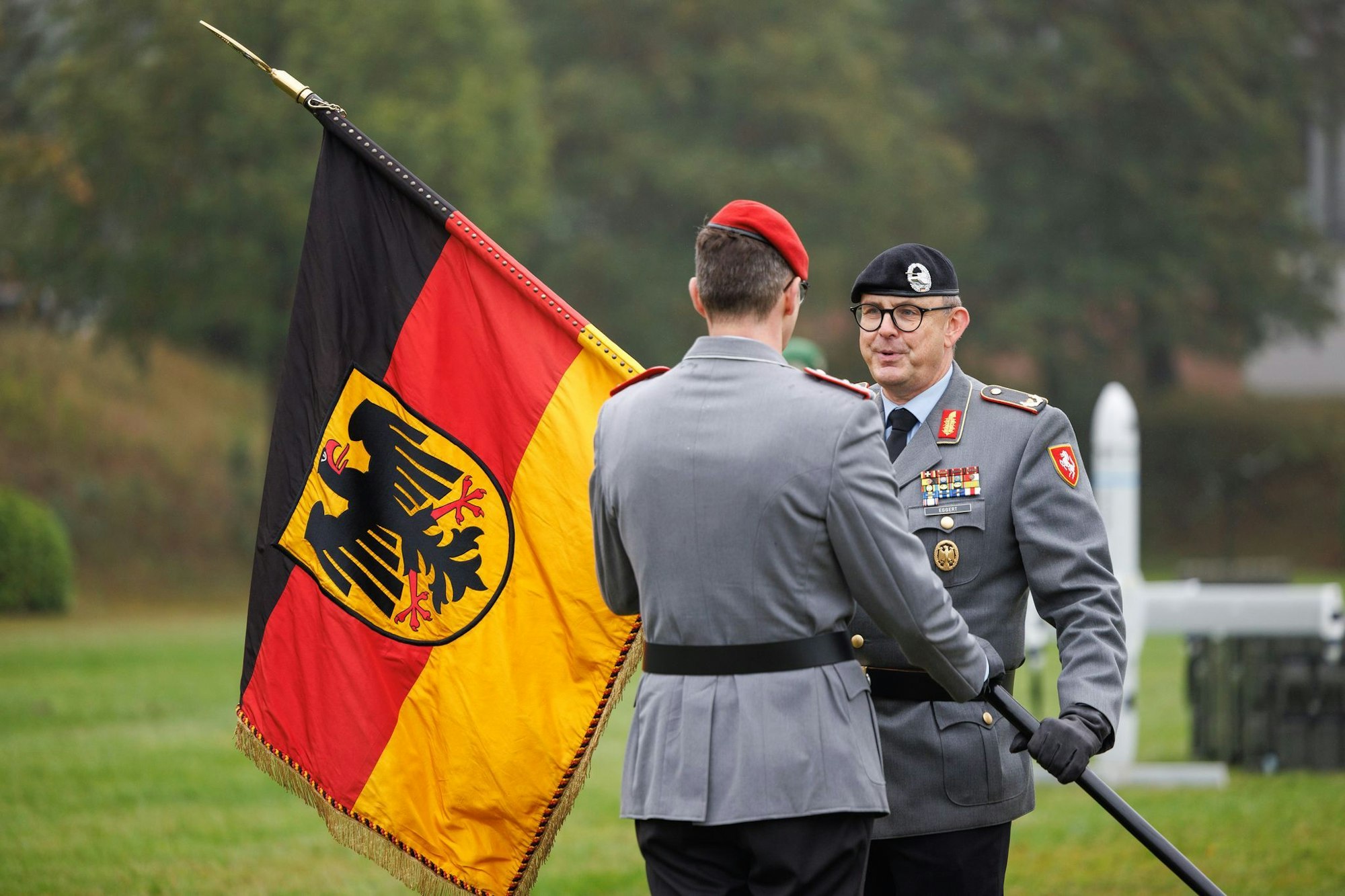Brigadegeneral Marco Eggert (r) übergibt eine Deutsche Fahne beim Feierlichen Appell für das neu aufgestellte Artilleriebataillon 215 in der General-Feldmarschall-Rommel-Kaserne.