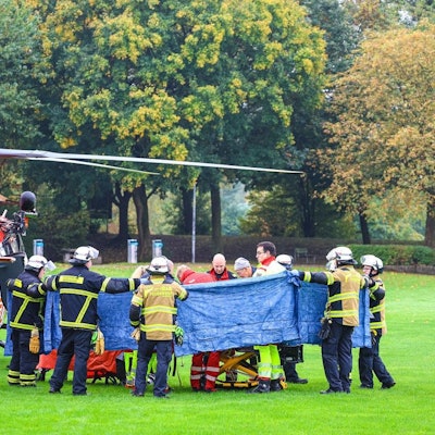Einsatzkräfte stehen neben einem Rettungshubschrauber. Die neu gewählte Bürgermeisterin von Herdecke, Iris Stalzer (SPD), ist lebensgefährlich verletzt in ihrer Wohnung gefunden worden.