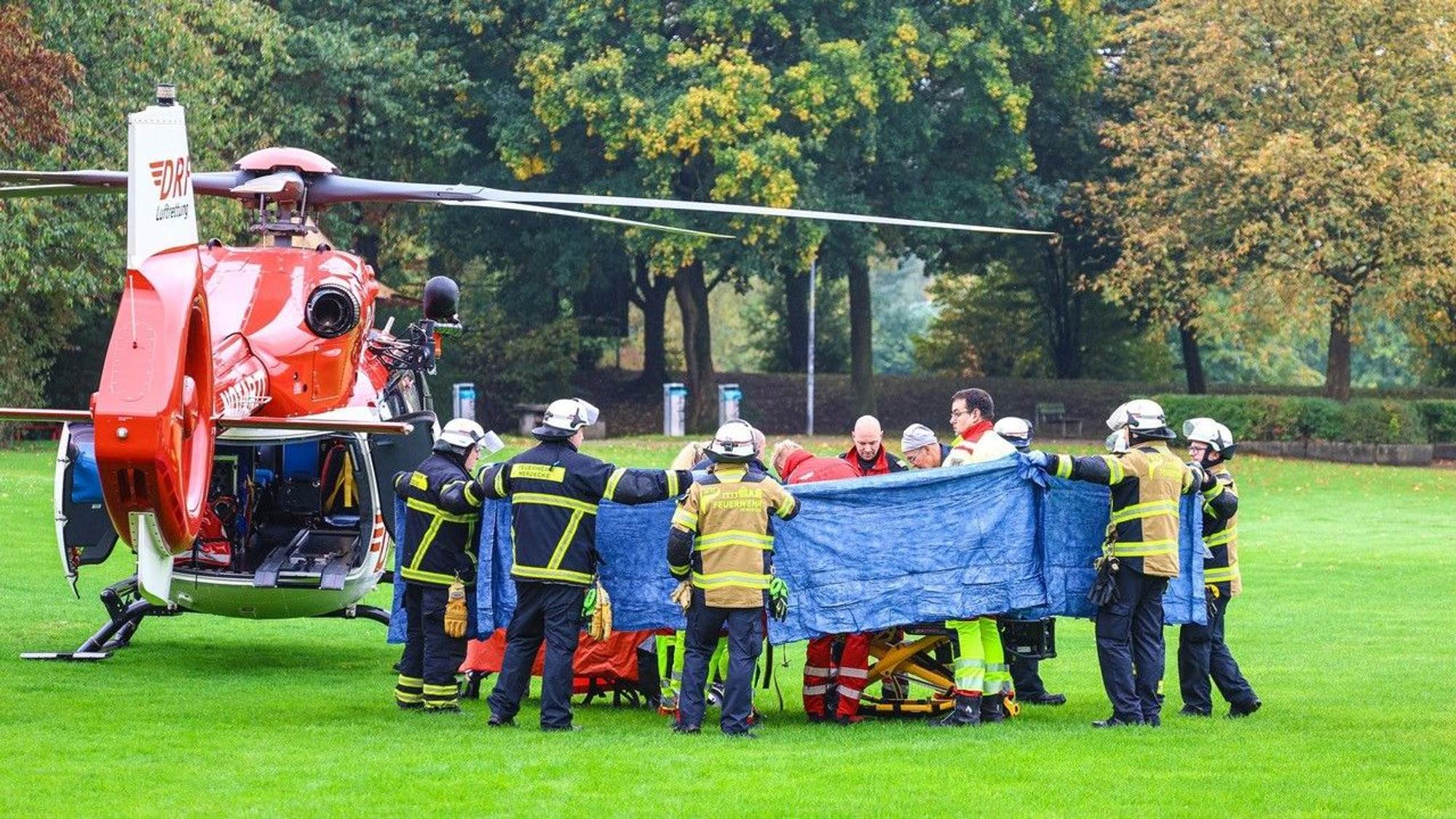 Einsatzkräfte stehen neben einem Rettungshubschrauber. Die neu gewählte Bürgermeisterin von Herdecke, Iris Stalzer (SPD), ist lebensgefährlich verletzt in ihrer Wohnung gefunden worden.