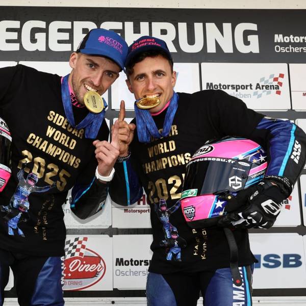 Zu sehen sind zwei Motorsportler, die auf Goldmedaillen beißen.