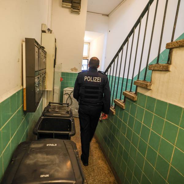 Ein Polizeibeamter geht in Hagen durch ein Treppenhaus bei einer Kontrolle im Kampf gegen kriminelle Geschäftsmodelle mit Schrottimmobilien und Sozialbetrug.
