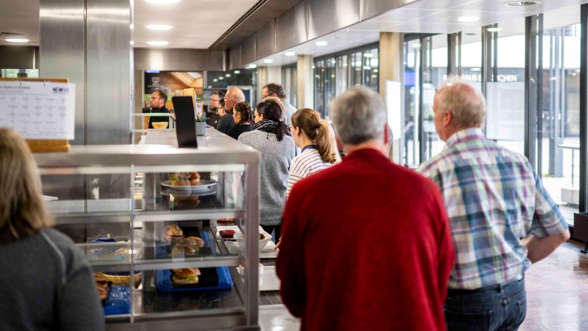 Das Bild zeigt eine Warteschlange in der Kantine in der Kreisverwaltung.