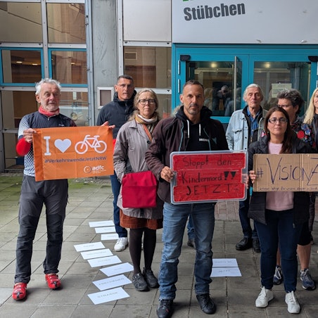 Das Foto zeigt Demonstrantrinnen und Demonstranten mit Plakaten vor dem Bürgerhaus.