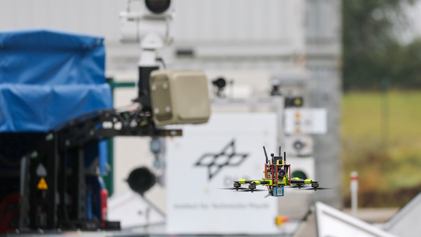 Eine Drohne fliegt vor einem Flybot-Detektionssystem mit Radar und Wärmebildkamera des Deutschen Zentrums für Luft- und Raumfahrt auf dem Flughafen Cochstedt.
