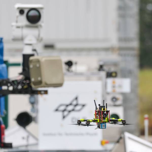 Eine Drohne fliegt vor einem Flybot-Detektionssystem mit Radar und Wärmebildkamera des Deutschen Zentrums für Luft- und Raumfahrt auf dem Flughafen Cochstedt.