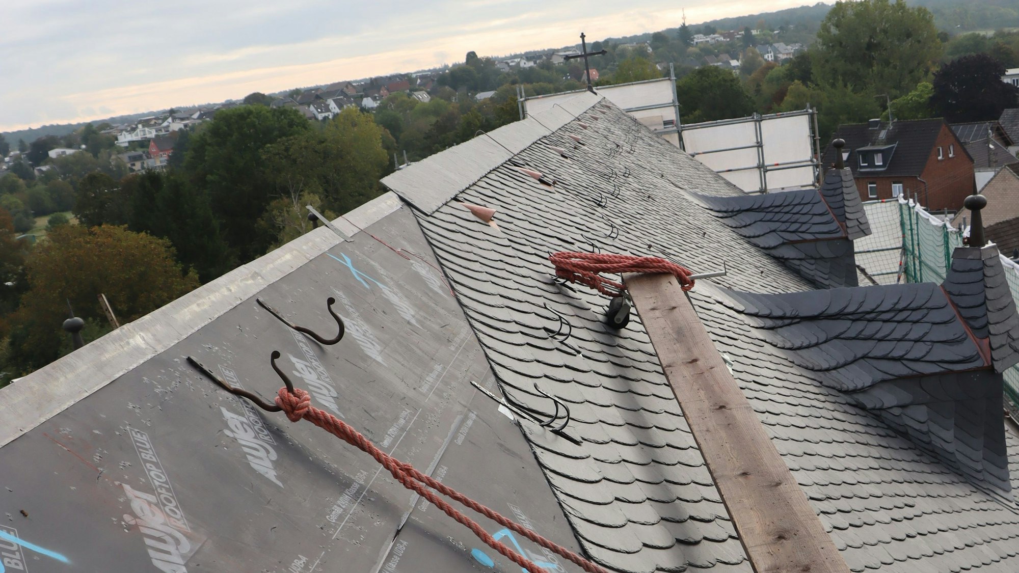 Zu sehen ist das Dach einer Kirche von oben, das neu gedeckt wird.