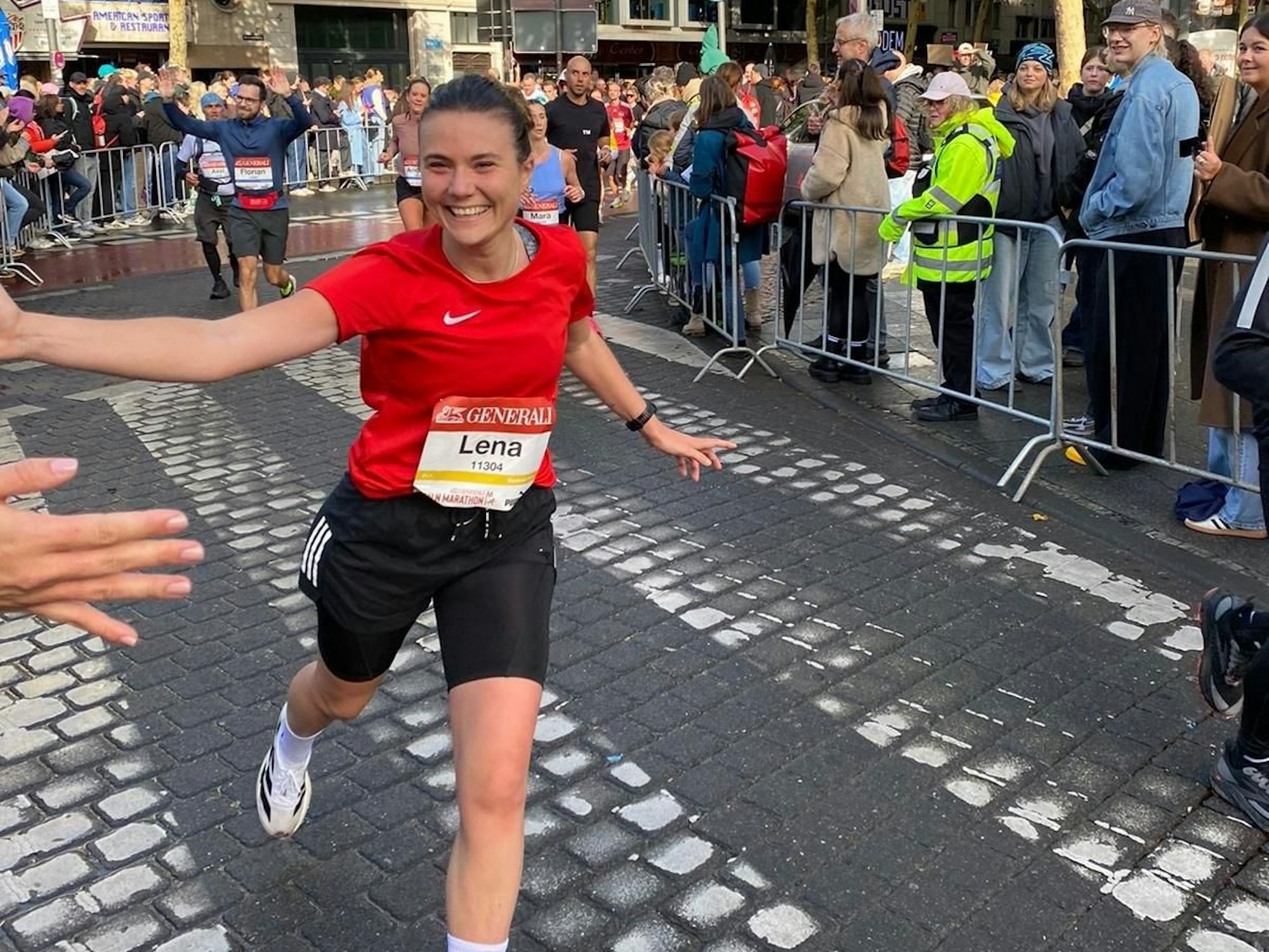 Lena Ganser holt sich grinsend Handschläge von den Menschen, an denen sie vorbeiläuft.