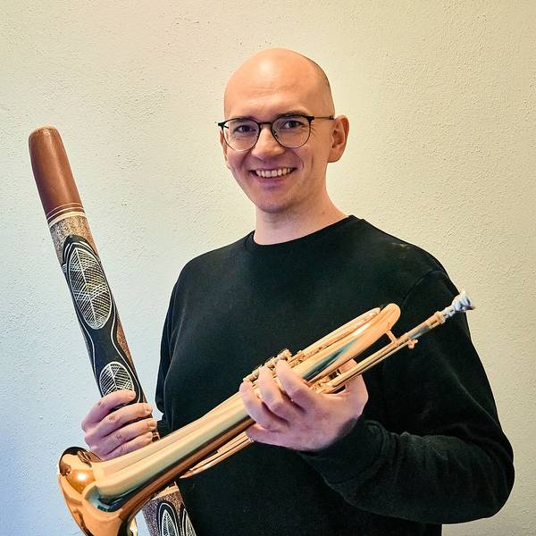 Kreisdirigent Nico Haag posiert mit zwei Instrumenten in den Händen.