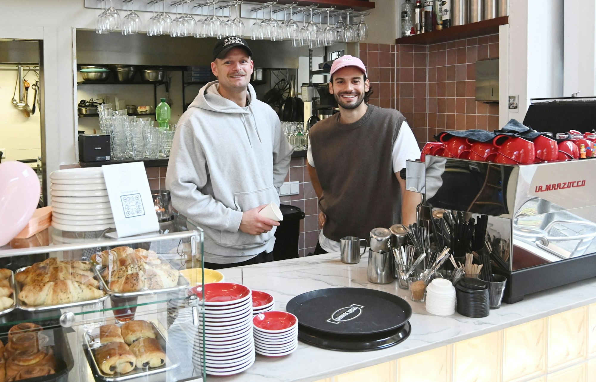 08.10.2025 Köln. Café und Bar Erste Liebe hat im Juni neu aufgemacht und sieht ganz ansprechend aus. Chris Schneider und Tim Stutzenstein (graues Shirt). Foto: Alexander Schwaiger