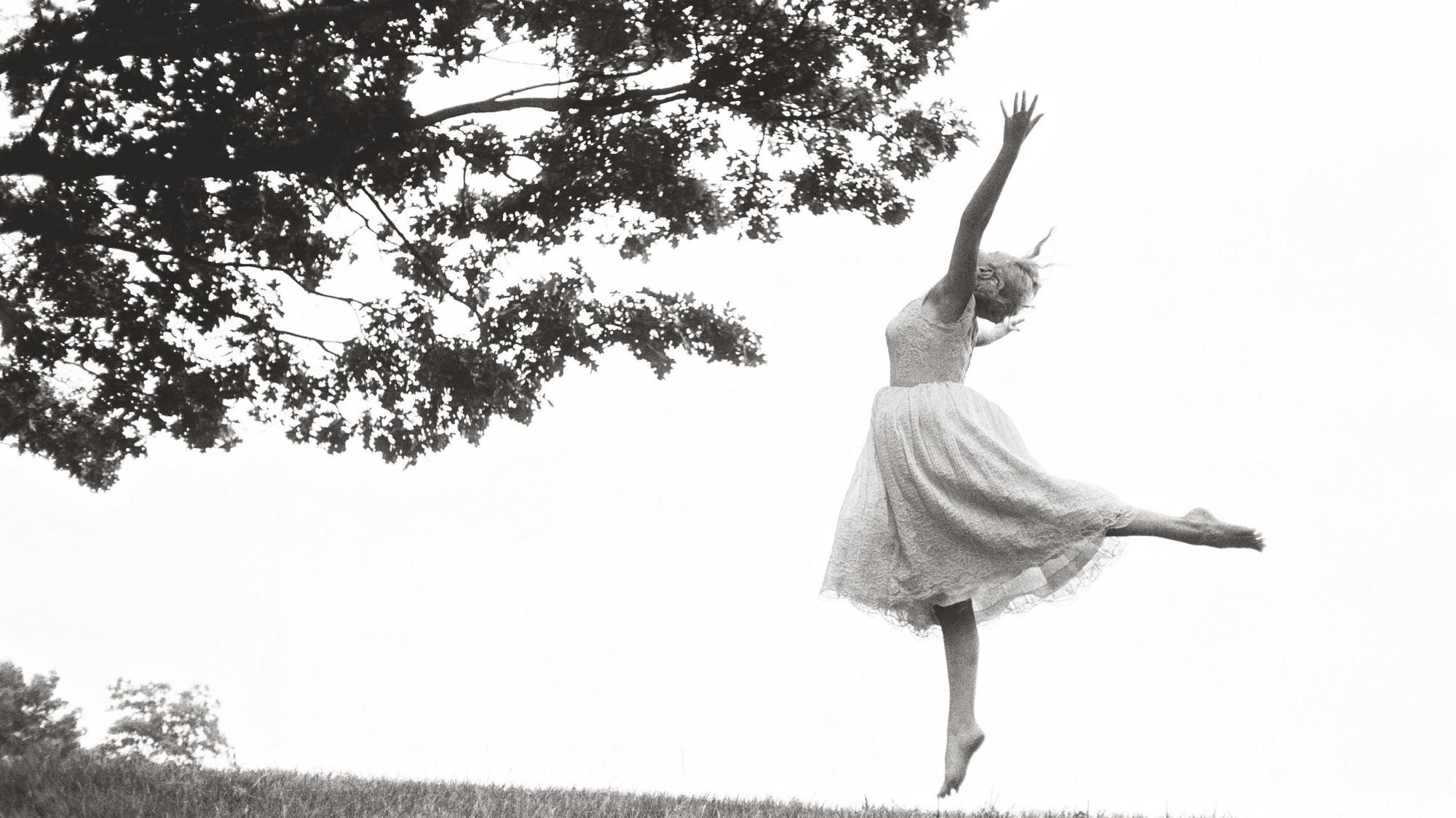 Marilyn Monroe tanzt barfuß auf einem Feld.