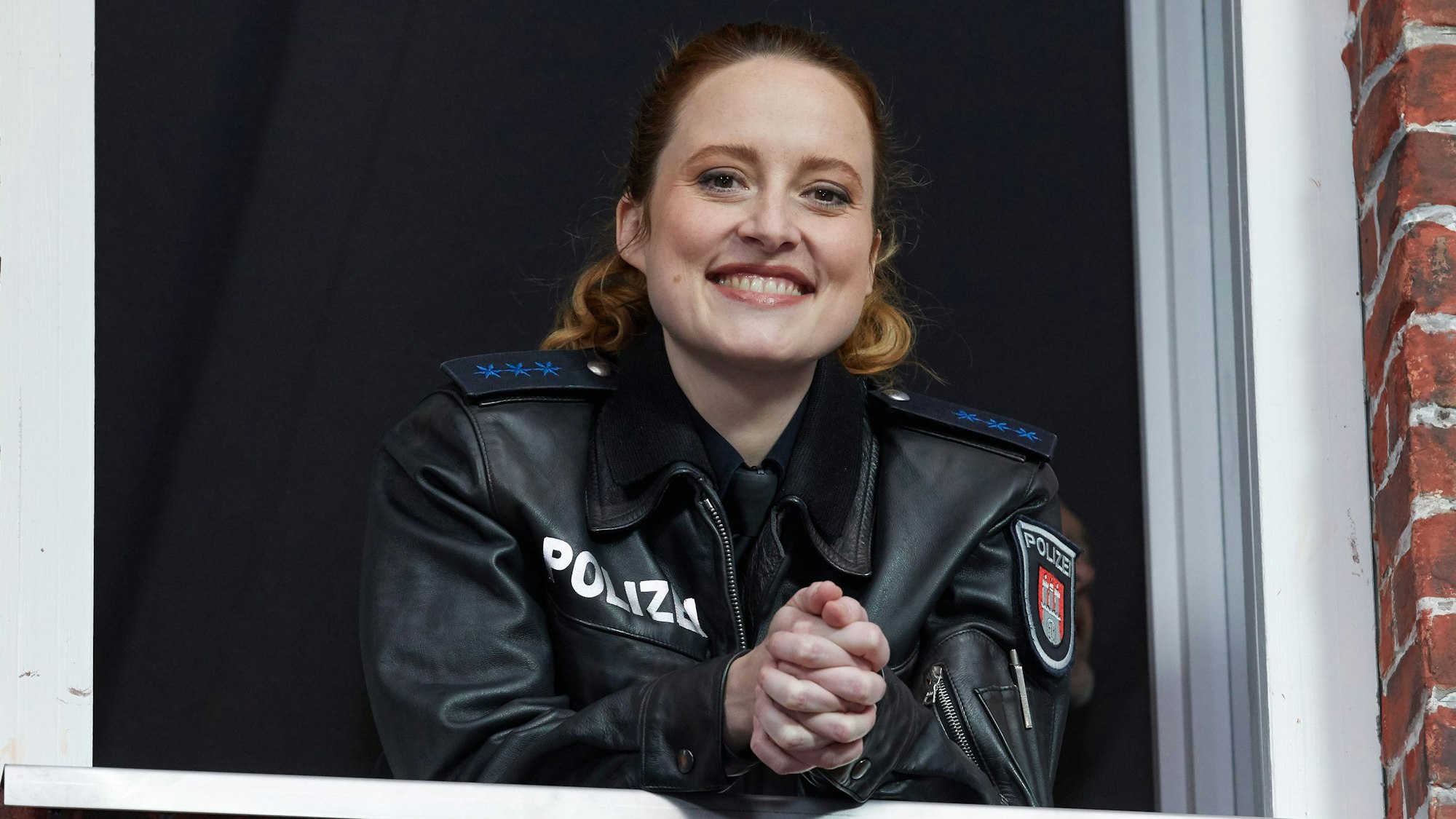 Wanda Perdelwitz lächelt in einer Filmkulisse.