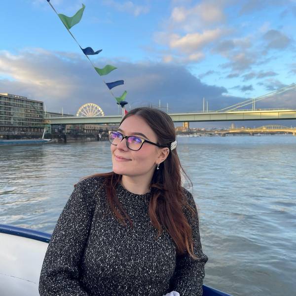 Yuliia Radchenko an einem Fluss. Im Hintergrund eine Brücke.