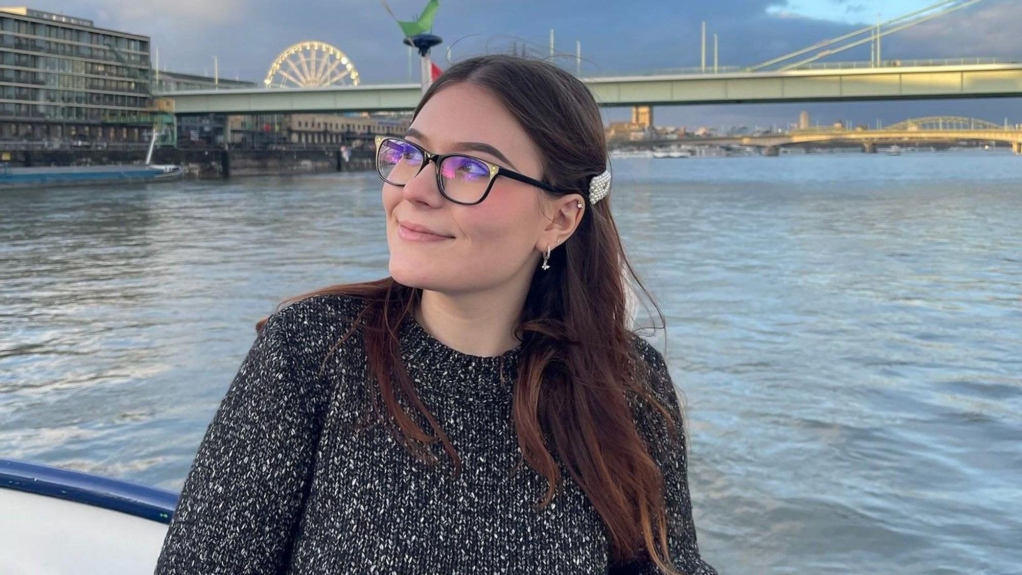 Yuliia Radchenko an einem Fluss. Im Hintergrund eine Brücke.